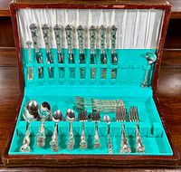 Open case showing two tiers of flatware in original fitted chest
