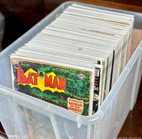Plastic bin filled with bagged and boarded comics, spines and top edges visible