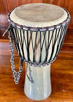 Full view of the djembe drum showing wooden body and rope tuning.