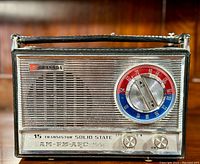 Front angled view of vintage Granada 15 transistor solid state radio showing speaker grill, tuning dial, power and band switches, and handle.