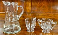 Glass pitcher, creamer, and sugar bowl clearly showing the etched Cornflower floral pattern on each piece, arranged side-by-side