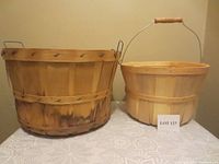 Both wooden baskets placed side by side on a table, showing the front and side views.