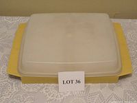 Closed yellow deviled egg container with a translucent lid on a lace cloth.