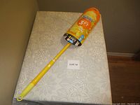 Photo of Swiffer duster laying on a patterned surface with visible packaging and label showing 3 ft length and pet hair suitability.