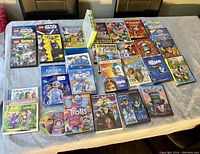 Photo of kids DVDs, Blu-rays and CDs arranged on a table showing various animated movies and music CDs.