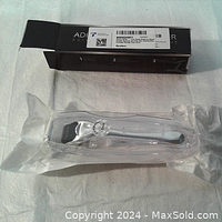 Full view of 0.1mm derma roller sealed in plastic with black storage box in background.