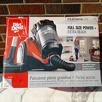 Dirt Devil FeatherLite vacuum cleaner original box showing branding, features like full size power, extra reach, cyclonic technology, bagless canister design.