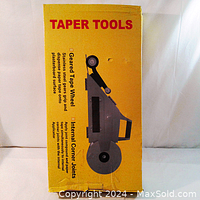 Yellow box packaging for drywall taping tool labeled 'Taper Tools' with image of the tool and key features including geared tape wheel and internal corner joints.