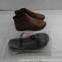 Brown lightweight ankle boots next to sealed flip flops showing the full lot contents