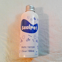 Front view of the white bottle with silver cap, label showing brand and product details.