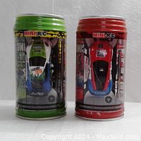 Front view of two mini R/C pop can racers in green and red can styled packaging.