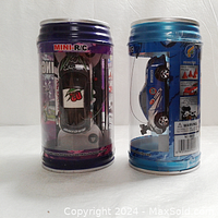 Two mini remote control pop can racers in packaging: one purple can with silver and green race car, one blue can with blue race car marked 05