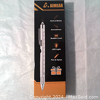 Front box view of AIMER multi-tool pen showing features icons and product image.