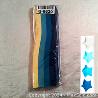 Photo of the sealed plastic package containing 500 origami paper strips in four pastel colors arranged adjacent to each other.