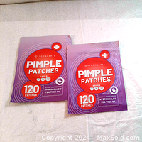 Two sealed packs of Key Concepts Pimple Patches, purple packaging with red and white labeling, indicating 120 patches per pack and active ingredients hydrocolloid and tea tree oil.