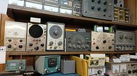 Shelf view showing four instruments: Eico Model 232 VTVM at left, Eico 145A signal tracer, Eico 655 capacitance meter, Heathkit IG-52 RF generator