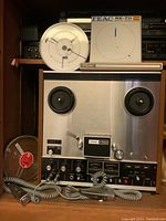 Front view of TEAC A-3300 deck with reels, microphones, and tape.