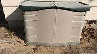 Front view of the Rubbermaid outdoor storage box showing split top lid and hinged front panels.