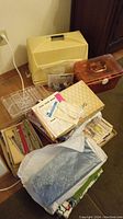 Overview of sewing machine, carrying case, sewing box, patterns, fabrics, needles, and accessories