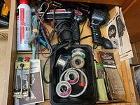 View showing three large black Weller soldering guns, soldering tips guide, spools of solder wire in a tray, and other soldering accessories.