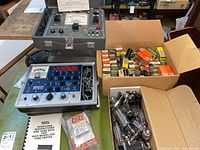 Overview of both tube testers, instruction manual, and two boxes of tubes
