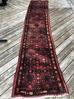 Full length view of red geometric-runner rug on wood deck