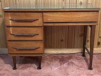 Front view of desk showing all drawers and glass top