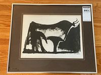 Framed lithograph showing abstract black bull image in mat and frame