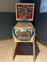 Full front view of pinball machine showing cabinet, legs and coin door