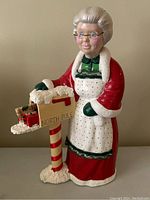 Full view of Mrs. Claus ceramic figure standing next to North Pole mailbox showing overall condition and size.