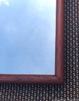 Close-up of mitered teak frame corner showing wood grain and finish