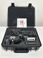 Hard plastic carrying case open showing Zhiyun Crane Plus gimbal and accessories arranged in foam insert