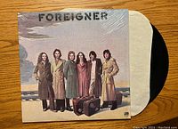 Front cover of Foreigner vinyl record album showing band members and band name with record sleeve partially visible.