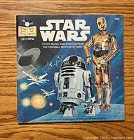 Front cover of vintage Star Wars book and record showing R2-D2 and C-3PO on a starry background with X-Wing starfighters.