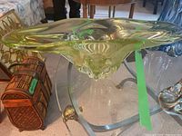 Front view of the elongated art glass bowl on a glass-topped table, showing overall shape and color.