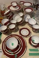 Overview of set arranged on table showing stacks of plates, bowls, cups and saucers