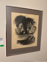 Full view of framed lithograph of a man and woman embracing, signed by Sandu Liberman.