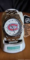 Front view of Montreal Canadiens watch with stainless steel bracelet and visible NHL tag detailing features.
