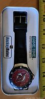 New Jersey Devils watch in original metal package with black band and team logo dial visible