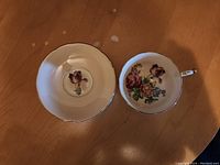 Tea cup and saucer shown from the top, showing floral designs and gold accents.