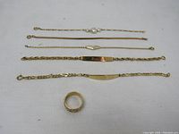 Overview of all six jewelry pieces including one ring and five bracelets arranged on white background.