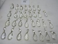 Full view of 31 clear white glass chandelier prisms laid out in rows