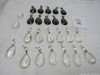 Overview of all 23 prisms including clear white and smokey colored glass teardrops arranged on white background.