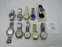 Full lot arranged in two rows showing all 10 wristwatches with varied styles and bands.