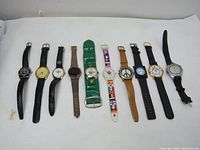 All 10 vintage wristwatches laid in a row with faces and straps visible on white background.