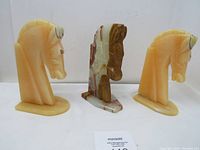 Front view showing set of three marble onyx horse head bookends and irregular stone piece in the middle
