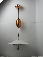 Full view of the lamp hanging on a plain background showing entire ceiling pull down mechanism and flying saucer metal shade