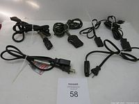 Six vintage appliance replacement power cords displayed on white background. One cord with cloth braided insulation cover, others with black plastic insulation. Visible plugs and appliance connectors vary.