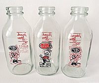 Front view of the three vintage glass milk bottles featuring Warner Brothers characters Bugs Bunny and the Tasmanian Devil with red and black graphics.
