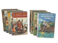 Photo showing all 8 Bobbsey Twins hardcover books arranged in two rows illustrating colorful illustrated covers depicting scenes from the stories.